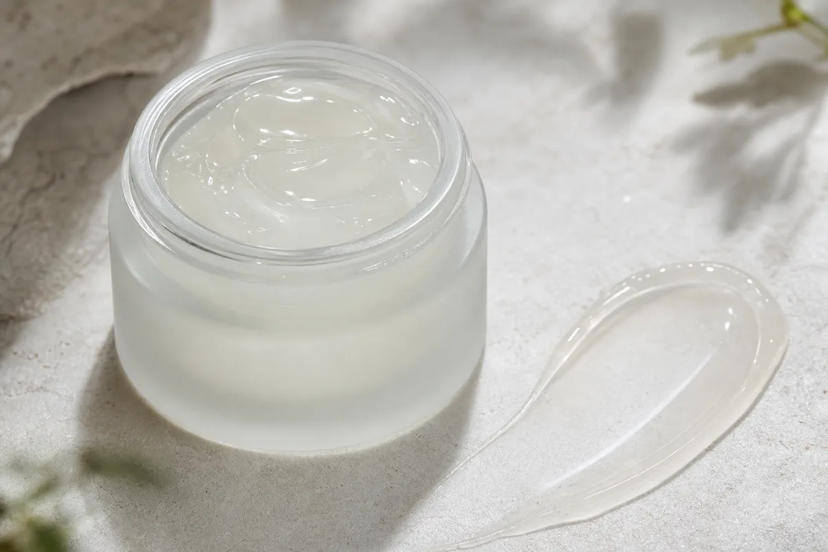 Pot de soin contour des yeux à la texture gel légère sur une surface neutre